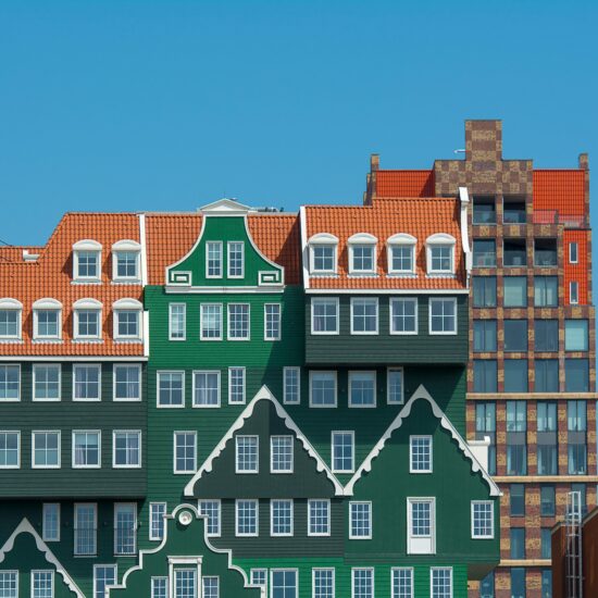 Vibrant facade of Inntel Hotels in Zaandam, featuring colorful, traditional Dutch architecture under a clear blue sky.